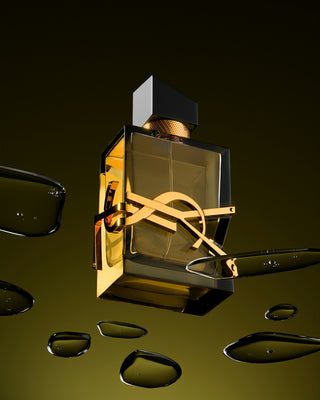 A bottle of perfume floating in the air next to a pair of scissors
