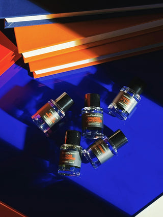 Five small perfume bottles arranged on a blue surface.